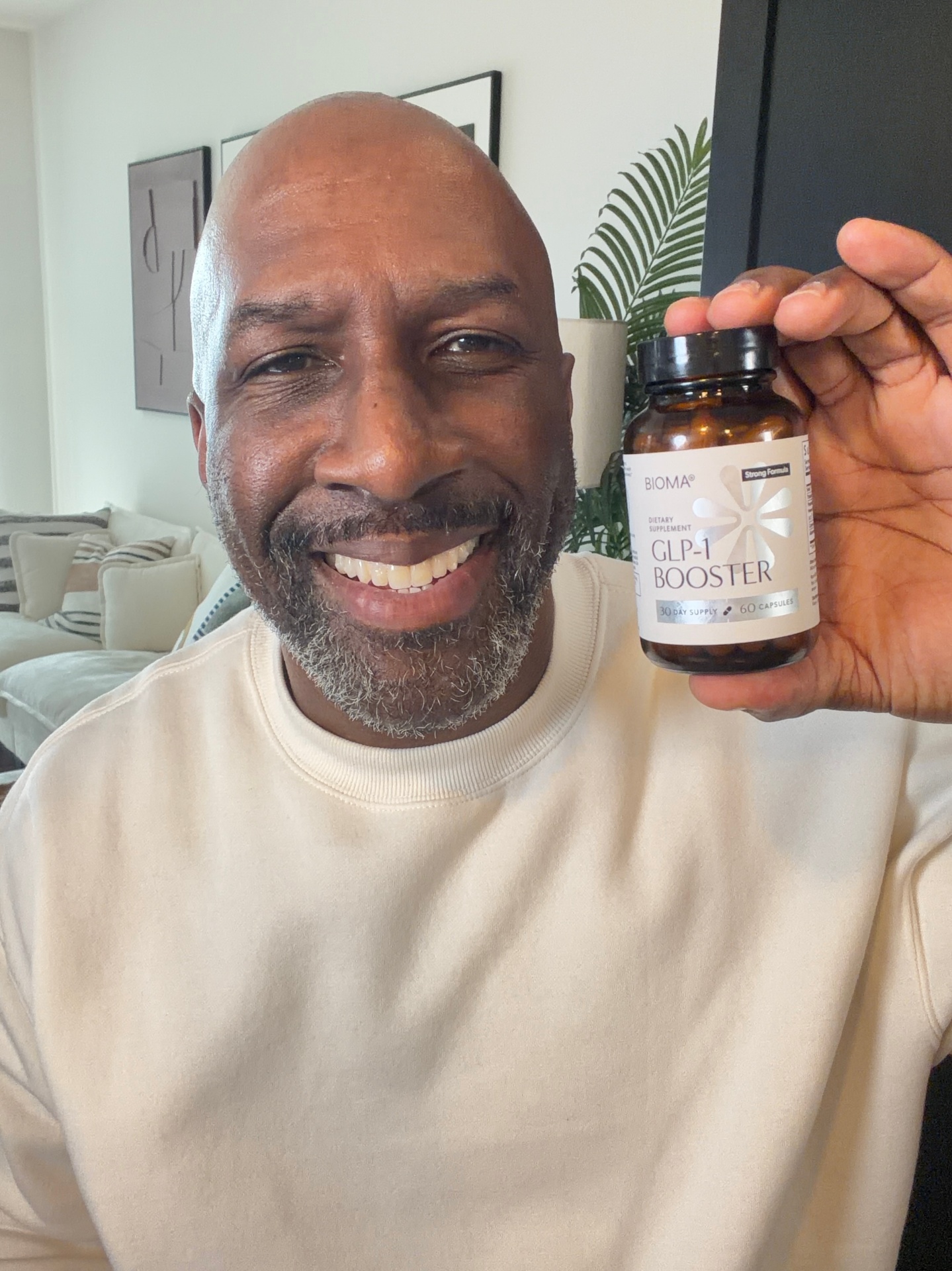 Man holding a bottle of GLP-1 Booster in his living room